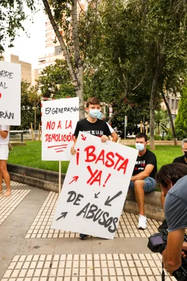 Kind mit einem Schild „¡Basta ya! de abusos“ bei einer Kundgebung der Anwohner